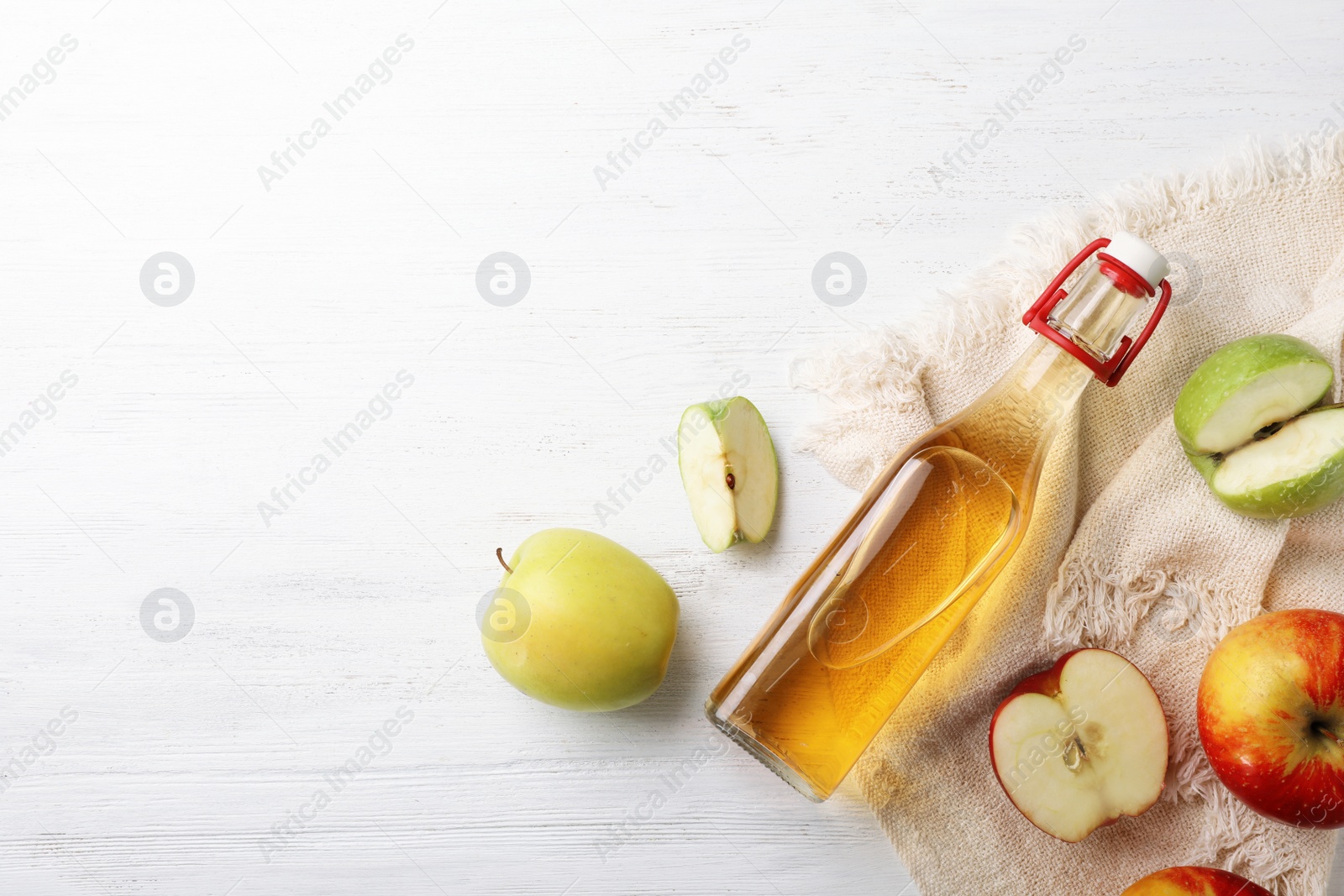 Photo of Flat lay composition with bottle of apple vinegar and space for text on wooden background