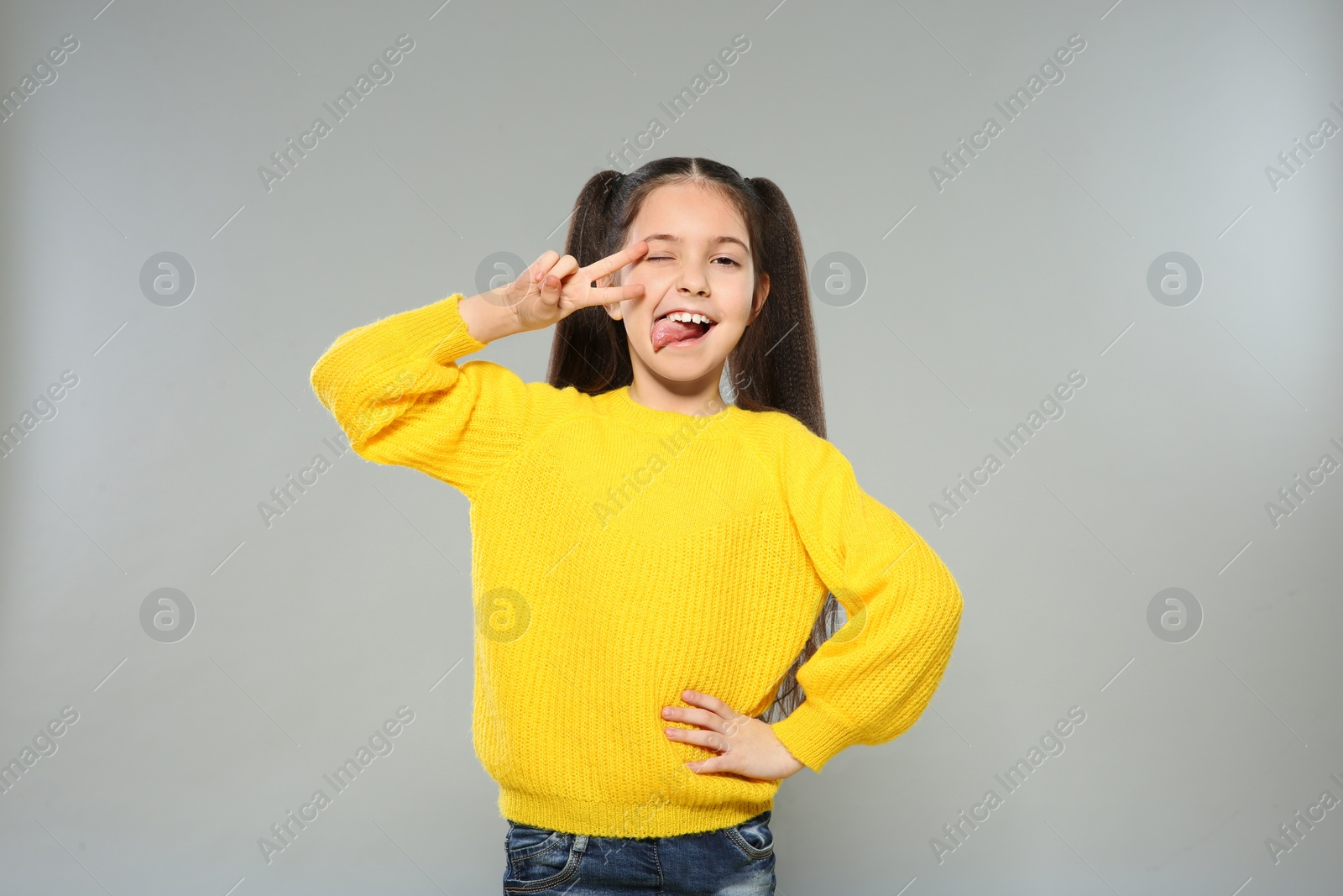 Photo of Portrait of little girl posing on grey background