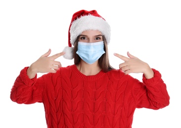 Photo of Pretty woman in Santa hat and medical mask on white background