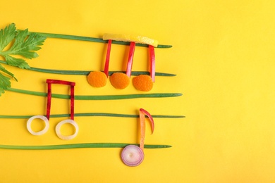 Photo of Musical notes made of vegetables and fruits on color background, top view. Space for text