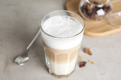 Photo of Delicious latte macchiato in glass on grey table