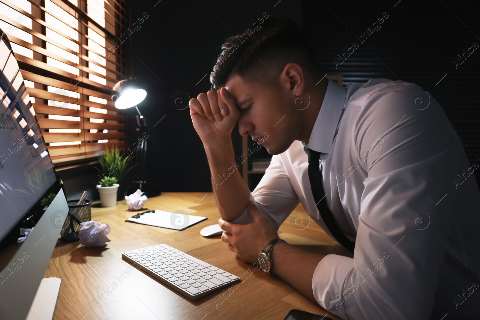 Photo of Businessman stressing out at workplace late in evening