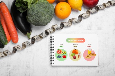 Image of Glycemic index. Information about grouping of products under their GI in notebook, measuring tape, fruits and vegetables on white textured table, flat lay