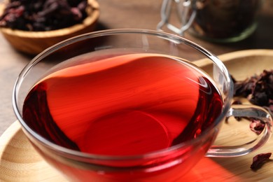 Cup of fresh hibiscus tea on table, closeup