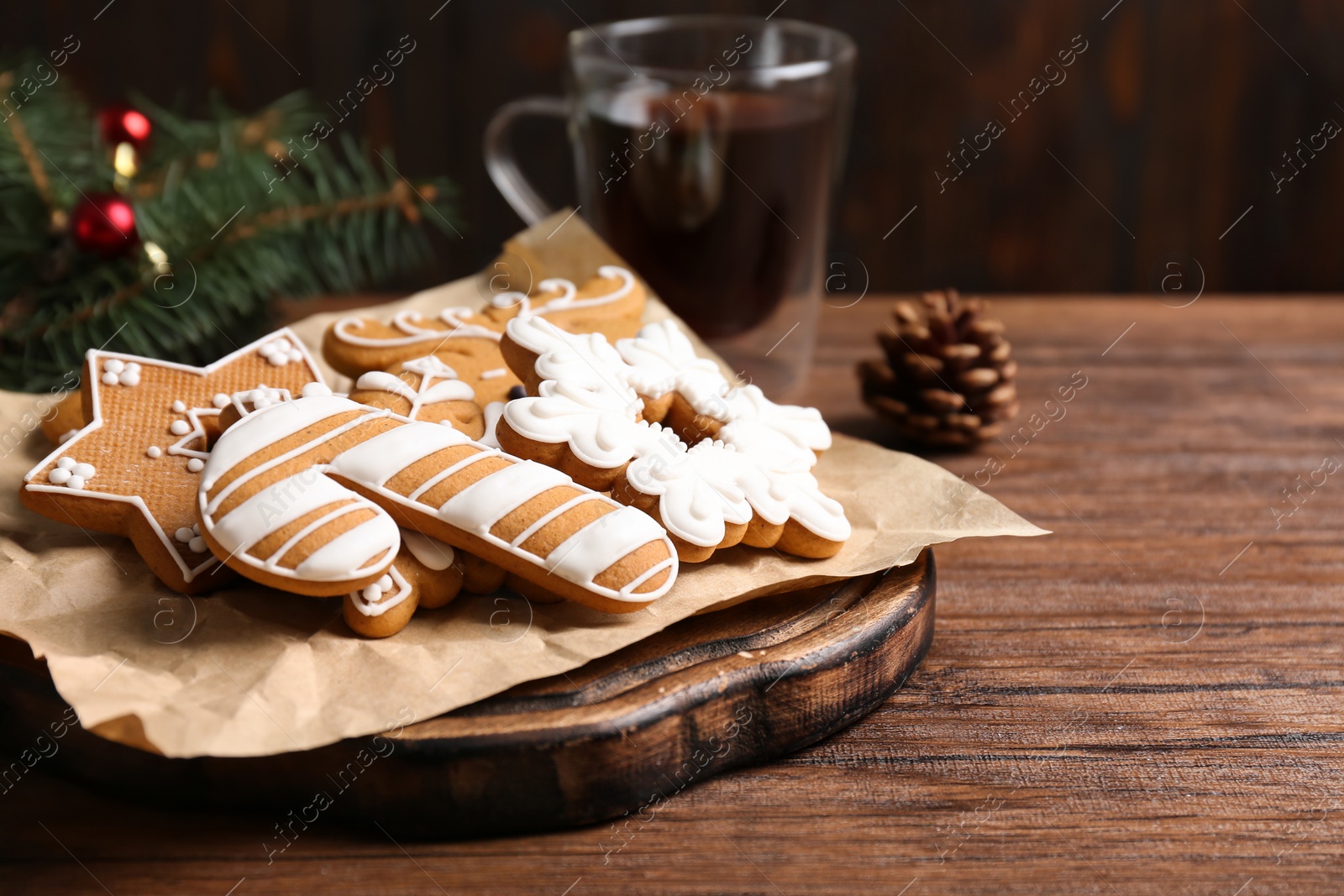 Photo of Board with tasty Christmas cookies on wooden table, closeup