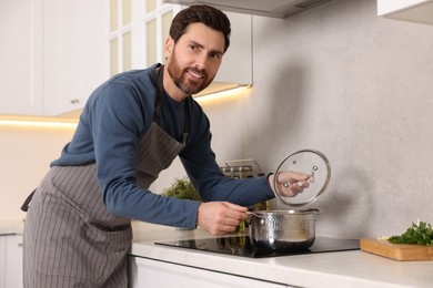 Man cooking soup on cooktop in kitchen