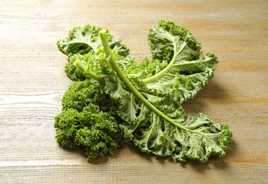 Photo of Fresh green kale leaves on wooden table