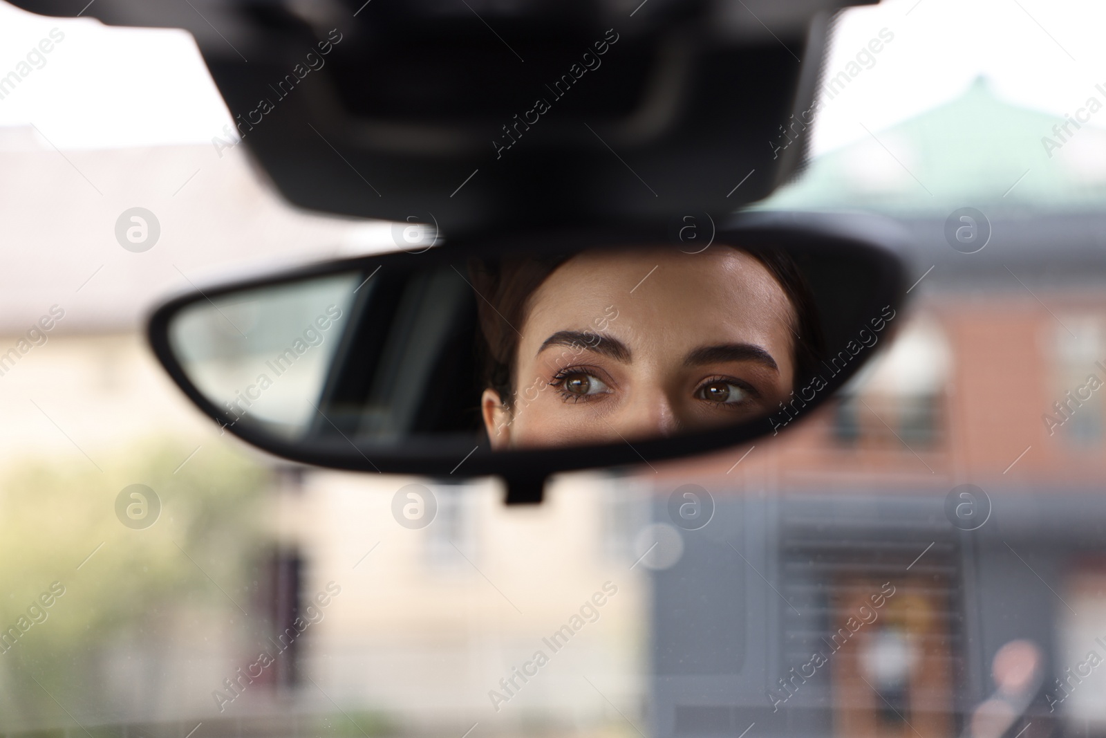 Photo of Woman driving her car, reflection in rear view mirror