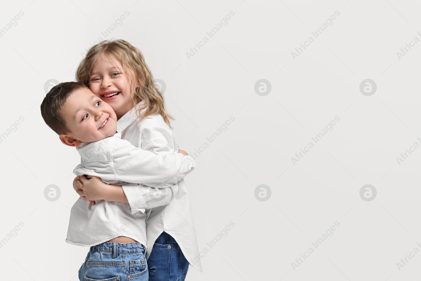 Photo of Cute little children hugging on white background. Space for text