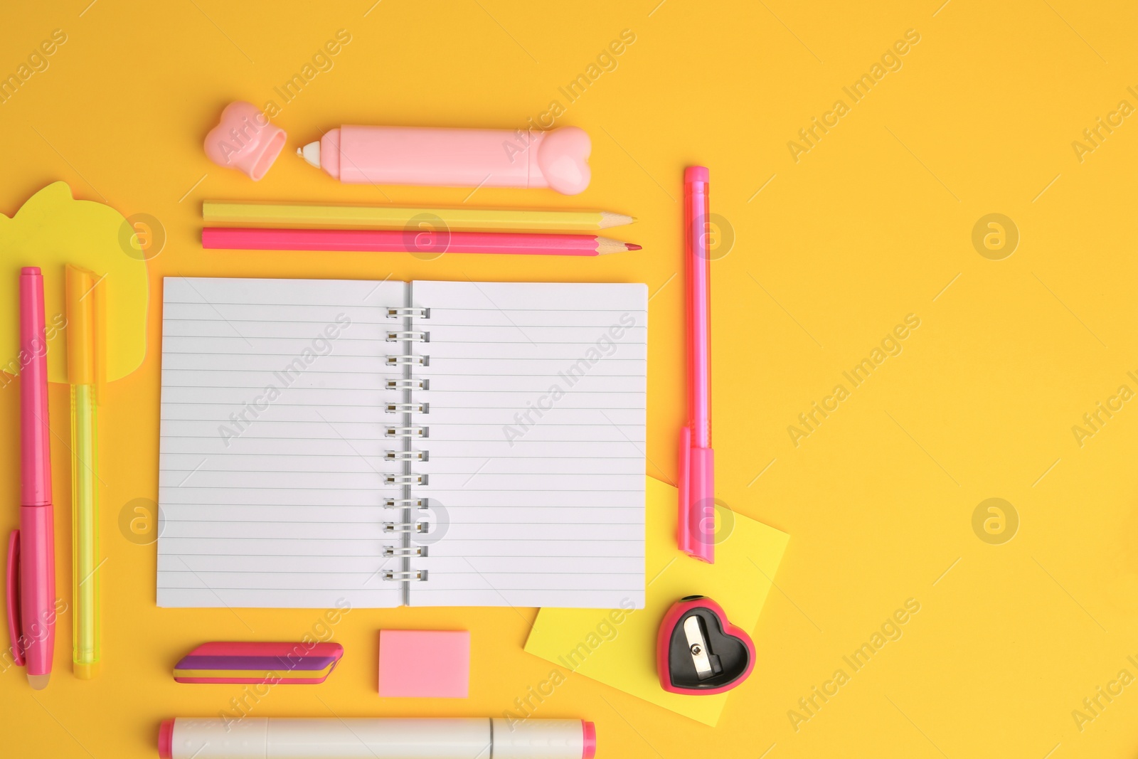 Photo of Flat lay composition with open notebook and different school stationery on yellow background, space for text. Back to school