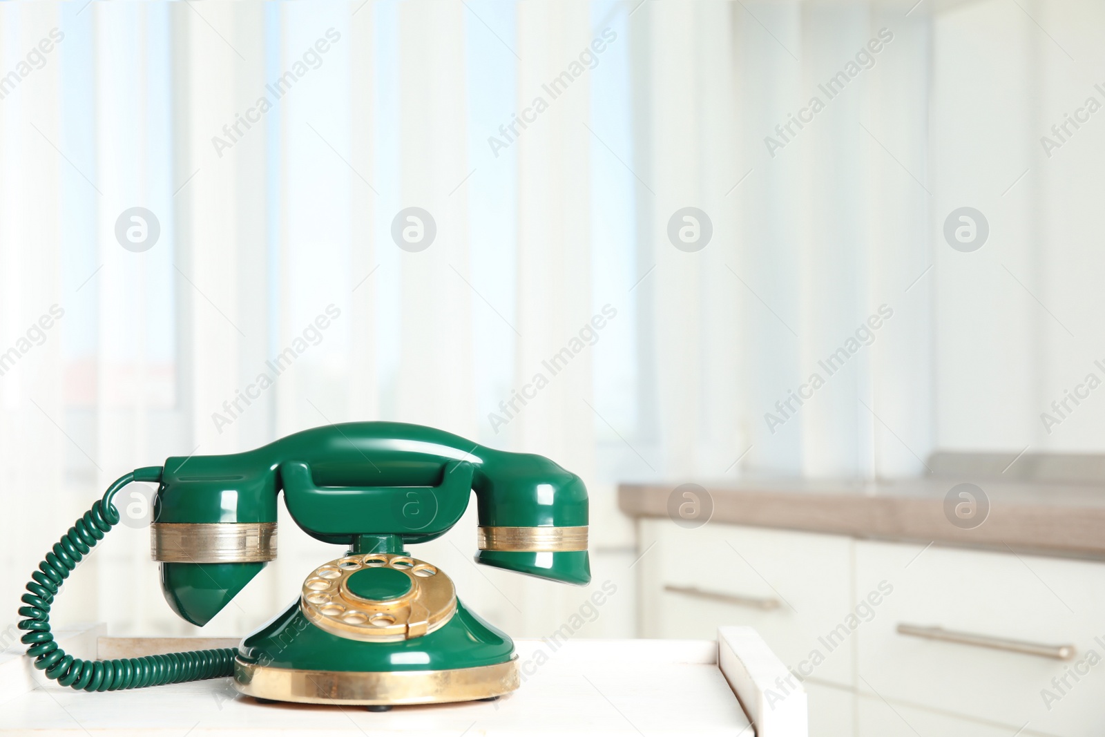 Photo of Vintage corded phone on white table indoors. Space for text