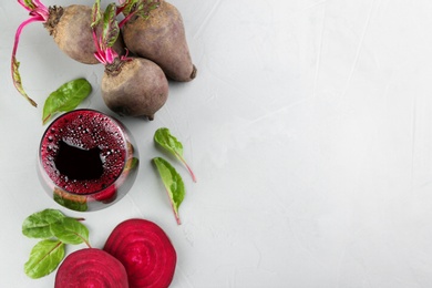 Photo of Freshly made beet juice on grey table, flat lay. Space for text