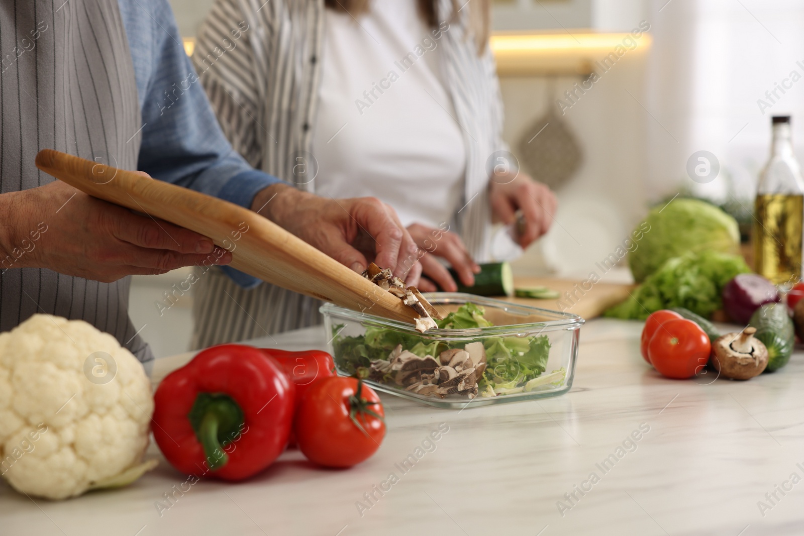 Photo of Senior couple cooking together in kitchen, closeup