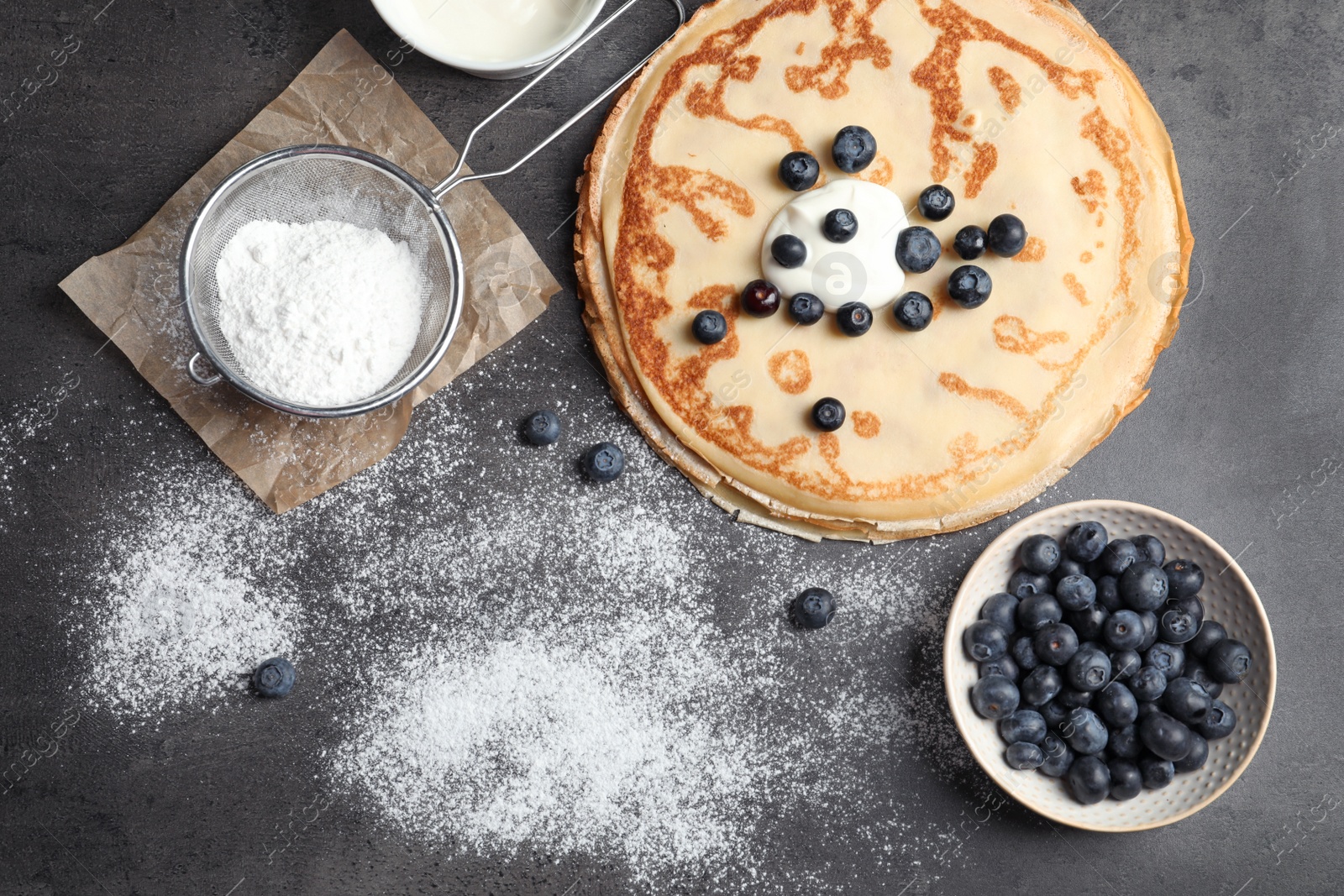 Photo of Flat lay composition with thin pancakes and berries on table