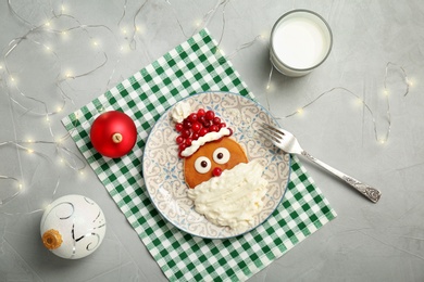 Flat lay composition with pancakes in form of Santa Claus on grey background. Christmas breakfast ideas for kids