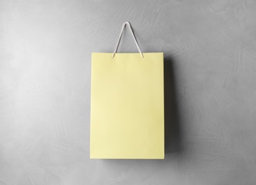 Paper shopping bag hanging on grey wall