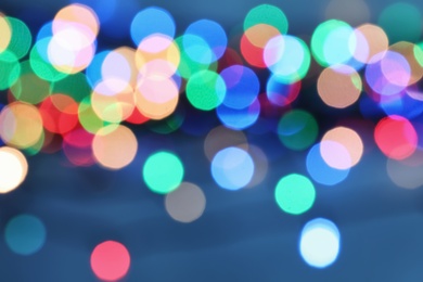 Photo of Blurred view of Christmas lights on color background