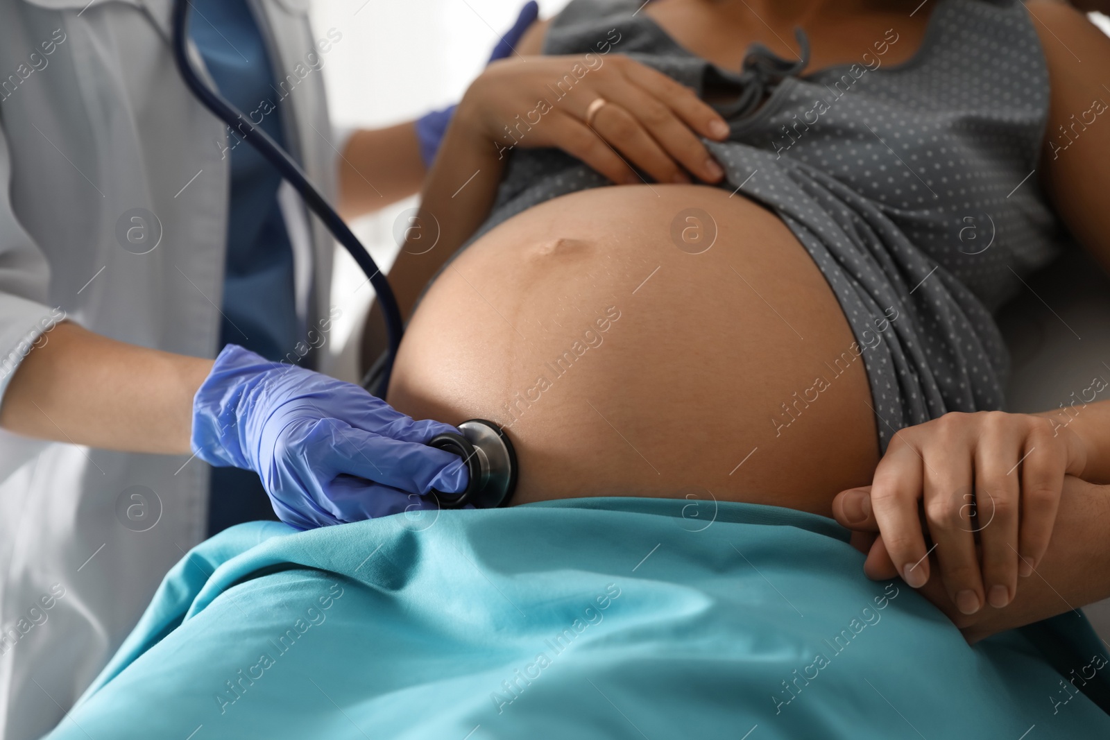 Photo of Doctor examining woman before giving child birth in maternity hospital, closeup