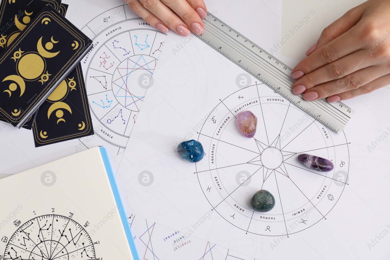 Photo of Astrologer using zodiac wheel for fate forecast at table, top view. Fortune telling