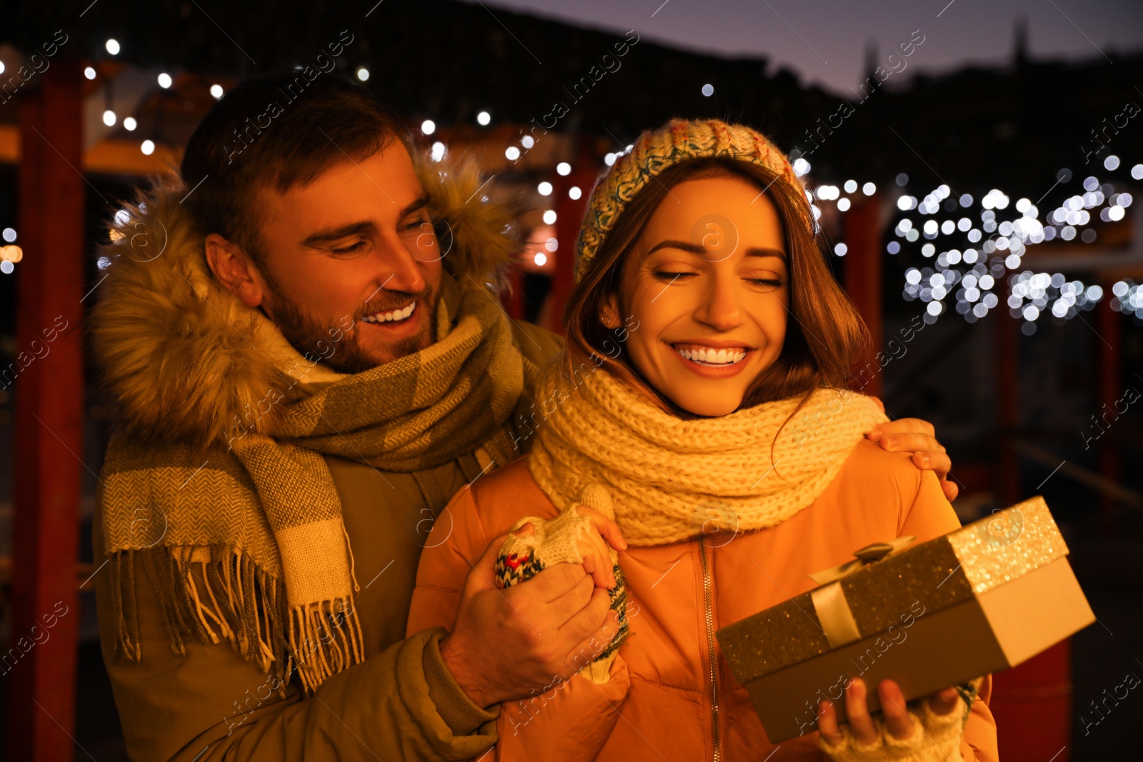 Photo of Happy couple with gift box at Christmas fair