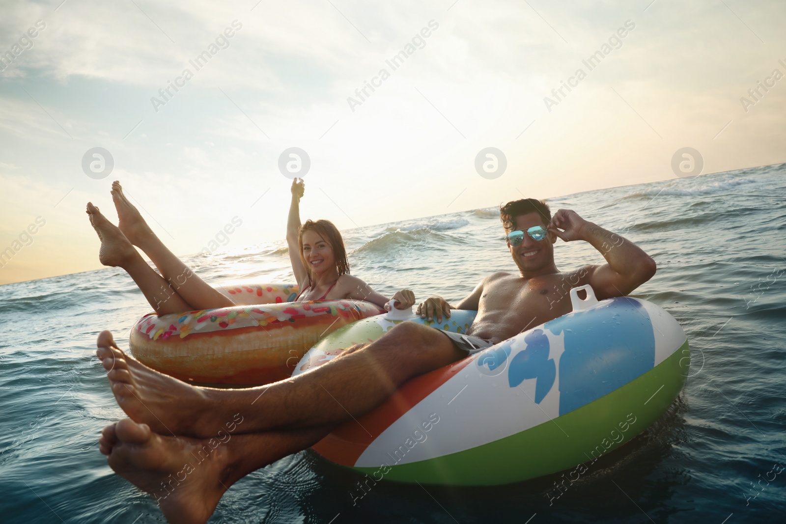 Photo of Happy couple with inflatable rings in sea