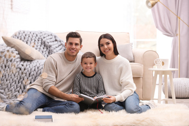 Photo of Happy family with little son reading book at home. Winter vacation