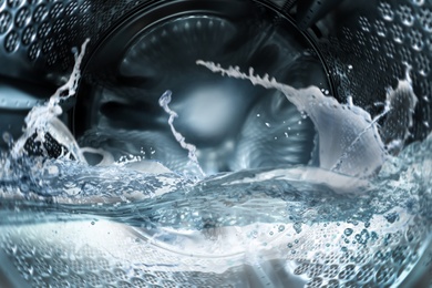Image of Washing machine drum with water, closeup view