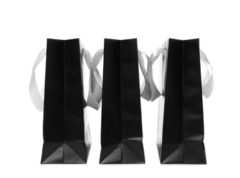 Photo of Paper shopping bags with ribbon handles on white background