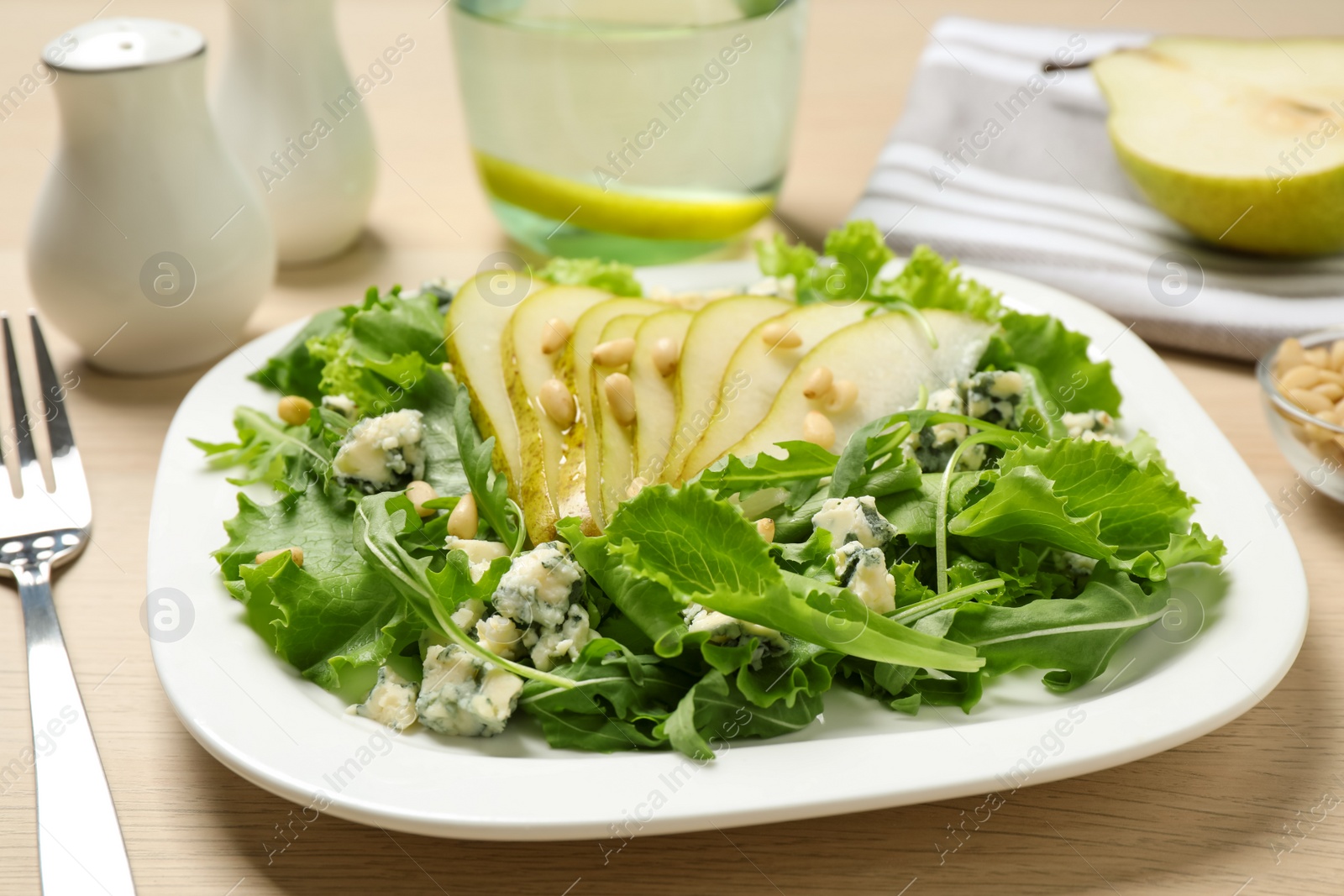 Photo of Fresh salad with pear served on wooden table