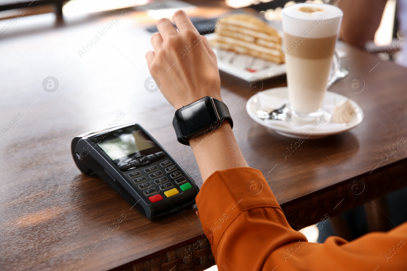 Photo of Woman making payment with smart watch in cafe, closeup