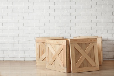 Wooden crates on floor near brick wall, space for text