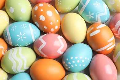 Many beautiful painted Easter eggs as background, top view