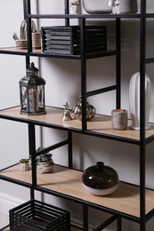 Photo of Shelving with different decor near white wall. Interior design