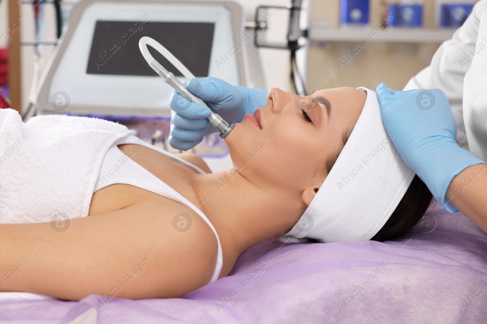 Photo of Young woman undergoing cosmetic procedure in beauty salon. Microcurrent therapy