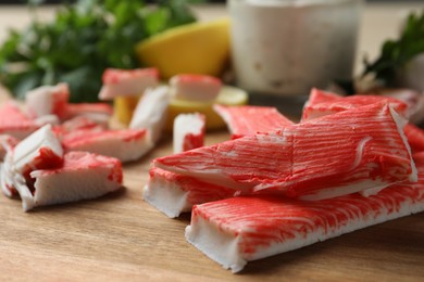 Delicious crab sticks on wooden board, closeup