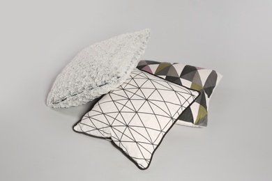 Pile of stylish decorative pillows on light background