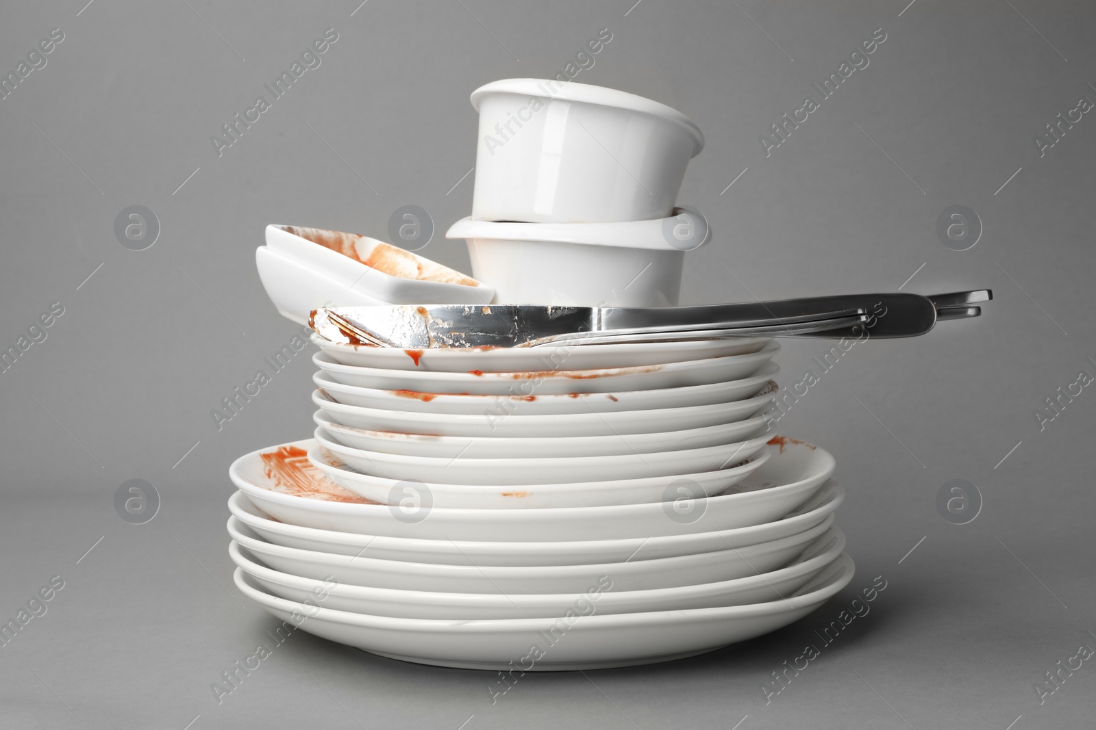 Photo of Set of dirty dishes on grey background