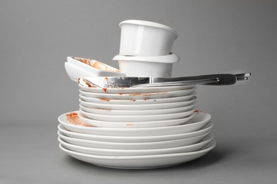 Set of dirty dishes on grey background