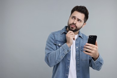 Photo of Man using smartphone on grey background, space for text