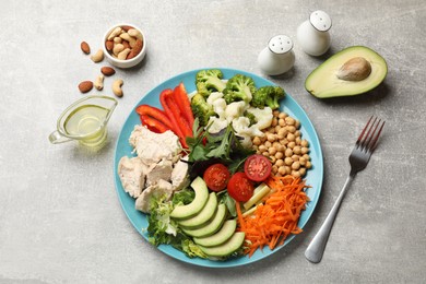 Balanced diet and healthy foods. Plate with different delicious products on grey table, flat lay