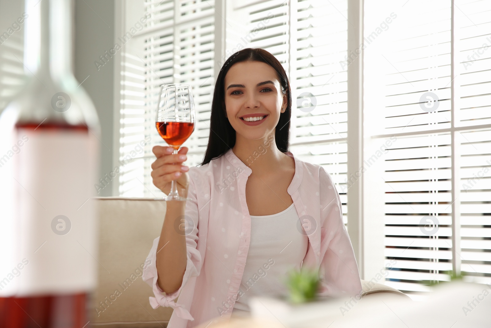 Photo of Woman drinking wine while having online video conference at home, view from web camera. Social distancing during coronavirus pandemic