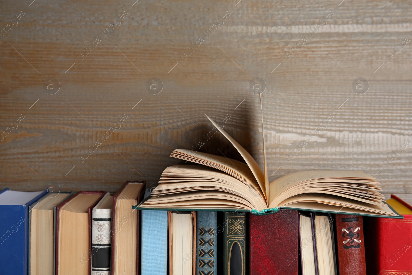 Photo of Different old hardcover books near wooden background