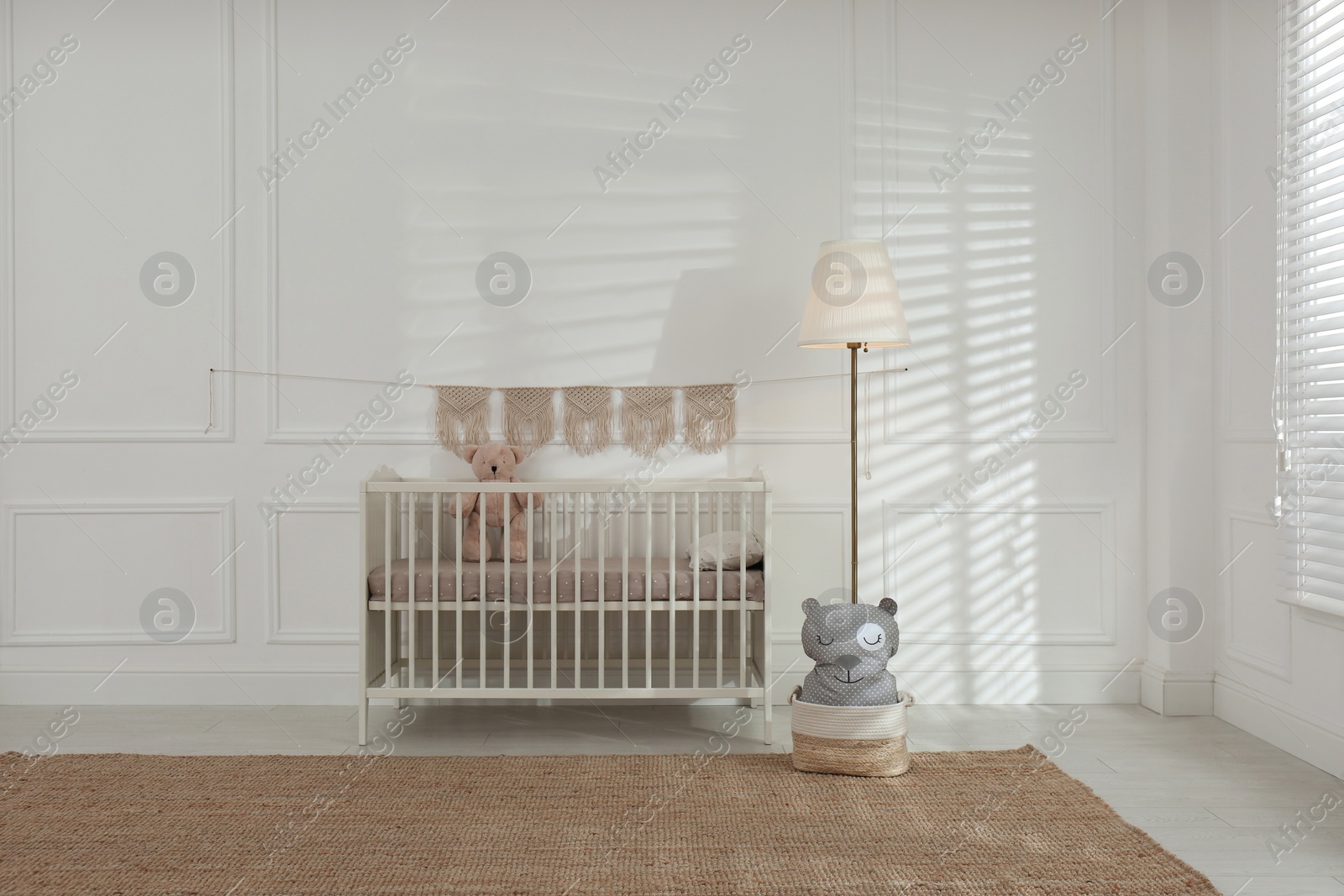 Photo of Cute baby room interior with comfortable crib and teddy bear