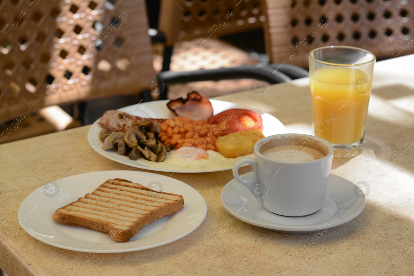 Photo of Cup of coffee and delicious breakfast served on beige table in cafe