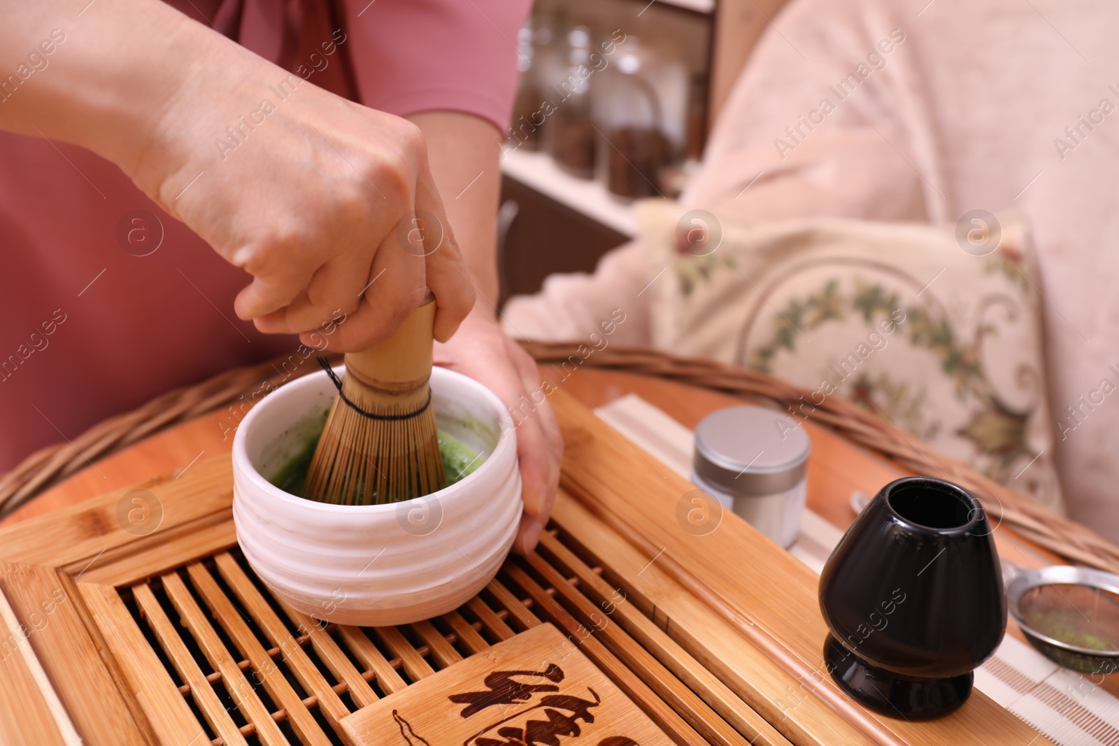 Photo of Master preparing matcha drink at wooden table, closeup. Tea ceremony