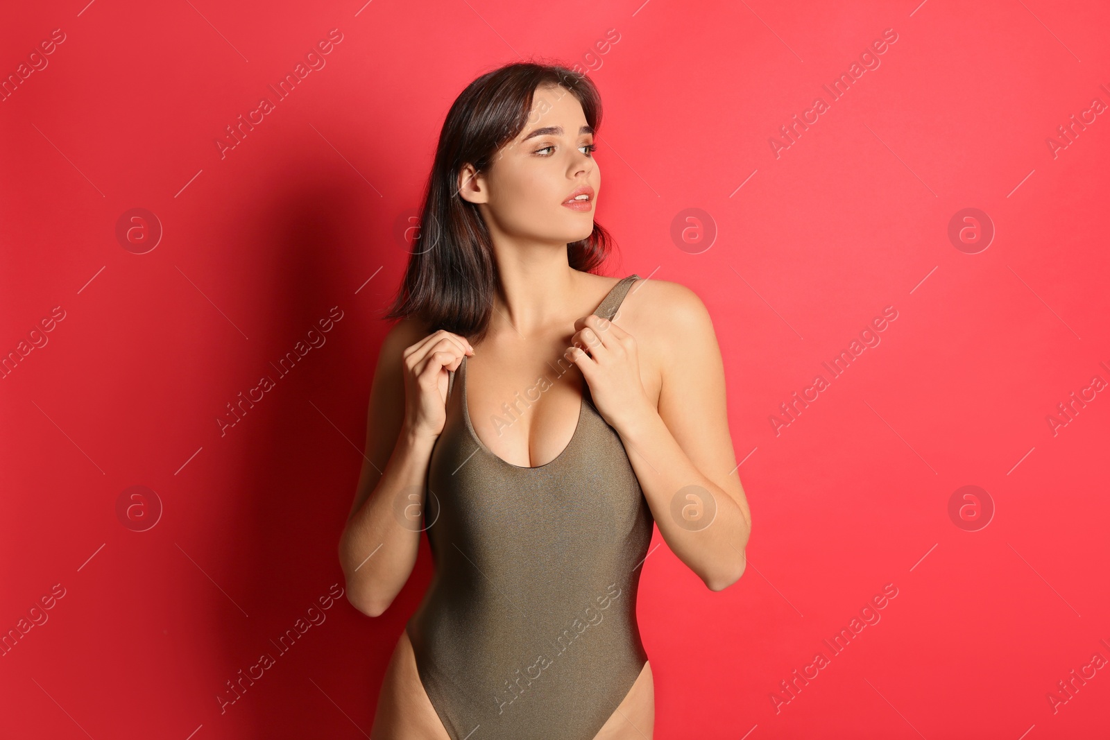 Photo of Beautiful woman in stylish swimsuit on red background