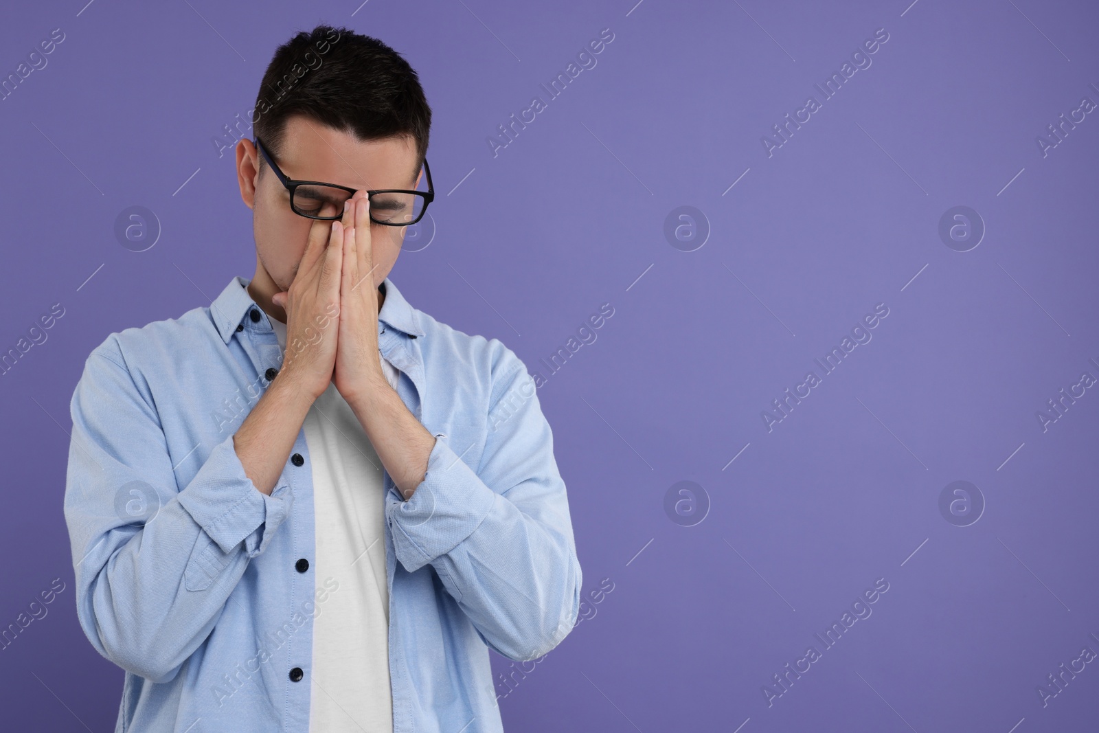 Photo of Resentful man on violet background, space for text