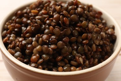 Photo of Delicious lentils in beige bowl, closeup view