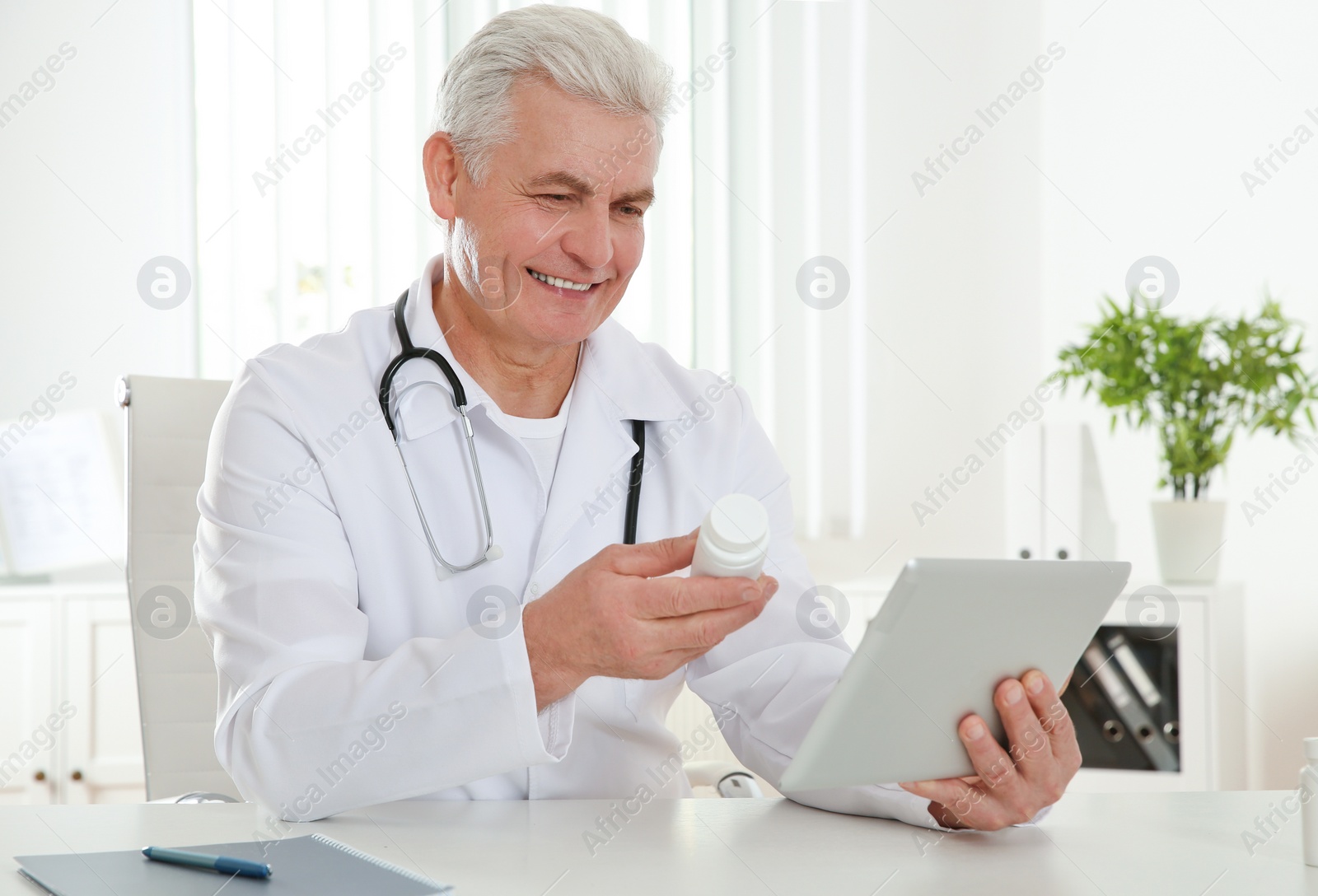 Photo of Doctor consulting patient using video chat on tablet in clinic