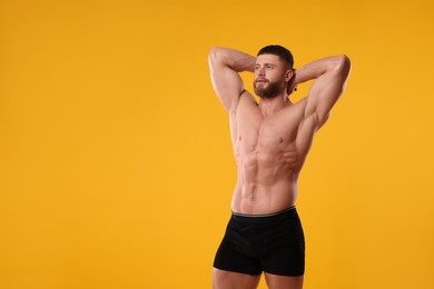 Photo of Young man is stylish black underwear on orange background. Space for text